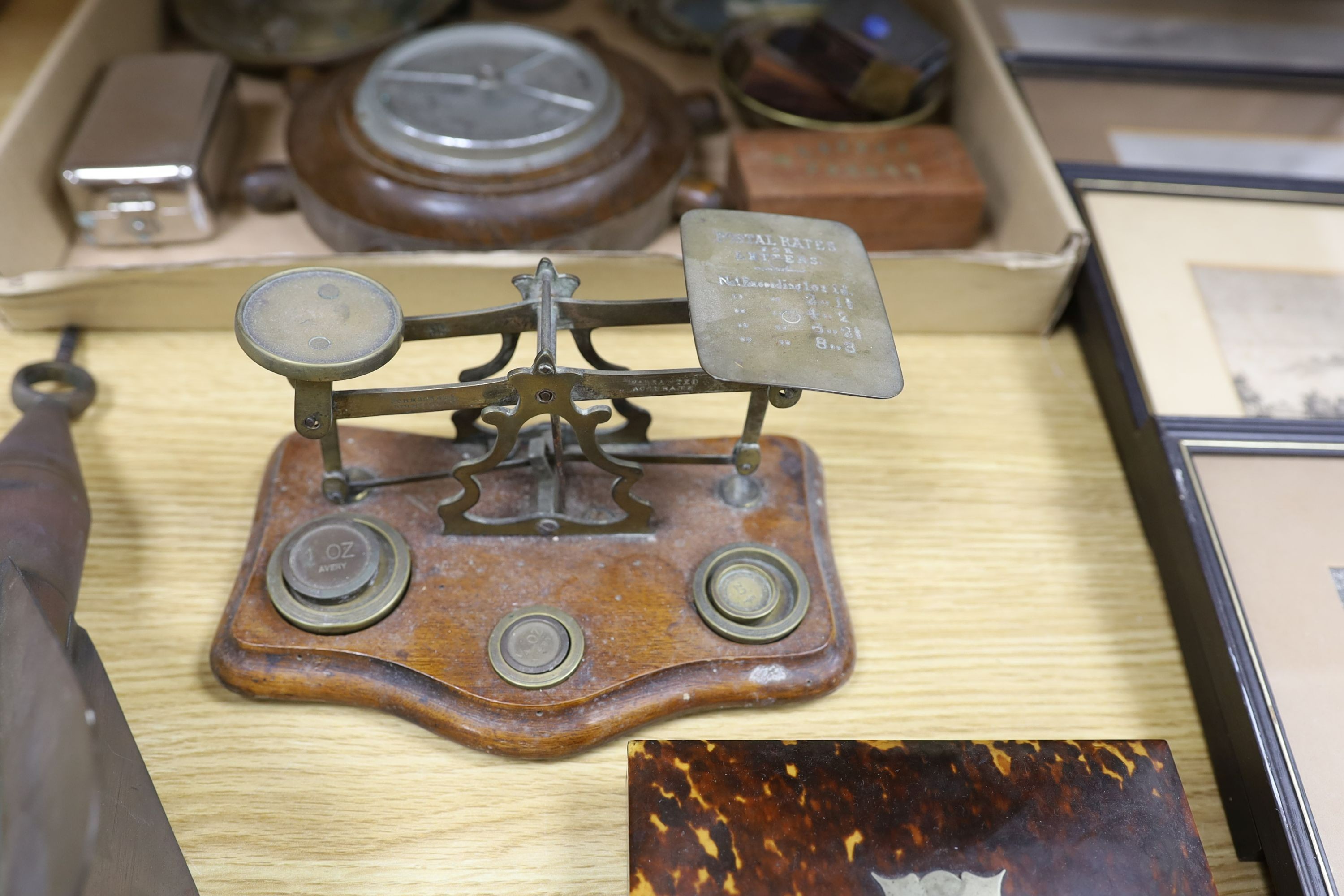 A box of curios including ship's log, brass projectile arrow and postal scales